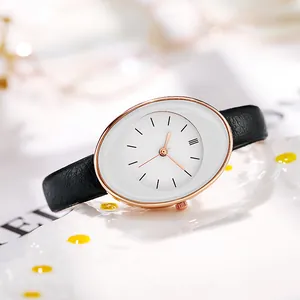 Macro shot of rose gold oval watch case with white dial and black leather strap detail