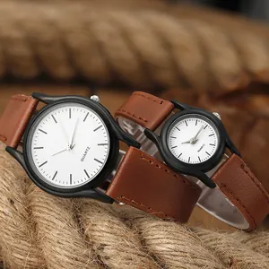 Primer plano de relojes para pareja con correas de cuero marrón sobre fondo rústico