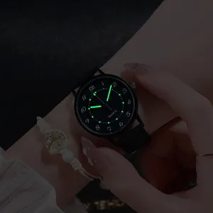 Orologio al quarzo nero con lancette e numeri luminosi in un ambiente scuro