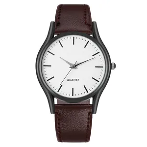 Detalle de reloj minimalista con correa de cuero marrón y caja negra mate con dial de cuarzo
