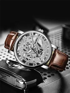 Skeleton dial watch with silver gears and brown leather strap on industrial background