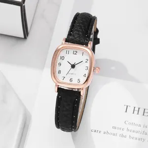 Details einer roségoldenen Quarzuhr mit weißem Zifferblatt und schwarzem Lederarmband