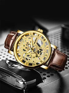 Detail of gold skeleton watch movement with brown leather strap and Roman numerals