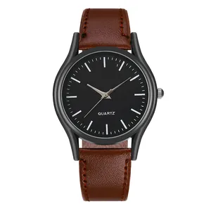 Detalle de reloj de cuarzo minimalista con correa de cuero marrón y esfera negra mate