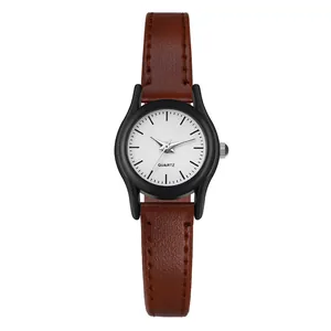 Detalle de reloj de cuarzo minimalista para mujer con correa de cuero marrón y esfera blanca