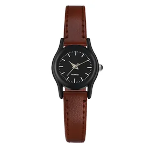 Primer plano de reloj de cuarzo minimalista con correa de cuero marrón y esfera negra