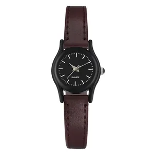 Detalle de reloj de cuarzo para mujer con correa de cuero burdeos y esfera negra minimalista