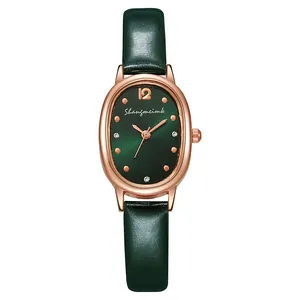 Detailaufnahme der ovalen rotgoldenen Uhr mit grünem Zifferblatt und grünem Lederarmband