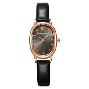 Detail der ovalen roségoldenen Uhr mit grauem Zifferblatt und schwarzem Lederarmband-Textur