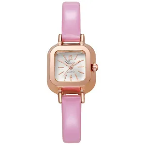 Vista macro detallada de un reloj cuadrado de oro rosa con correa de cuero rosa