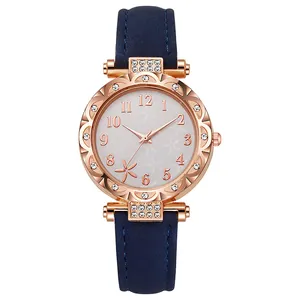 Detalle de reloj de cuarzo oro rosa con pedrería blanca y correa de ante azul