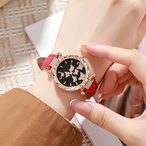 Close-up of stylish women's watch with red suede strap and rhinestone butterfly dial