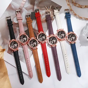 Mehrere modische Damenuhren mit roségoldenen Gehäusen und bunten Lederarmbändern auf dem Tisch