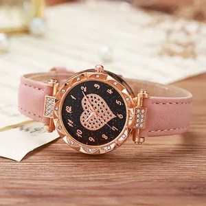Dettaglio della cassa in oro rosa con strass e cinturino in pelle rosa su spartito