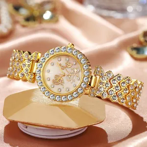 Primer plano detallado de un reloj dorado para mujer con bisel de cristal y esfera de mariposa
