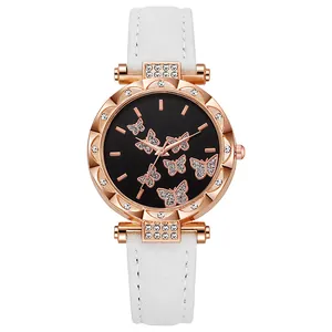 Detail of rose gold watch case with crystal bezel and butterfly motif on black dial