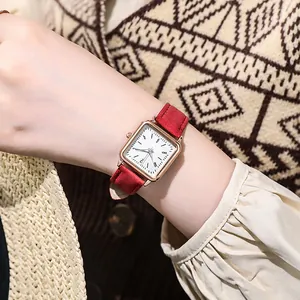 Primer plano de un reloj cuadrado vintage para mujer con caja de oro rosa y correa roja