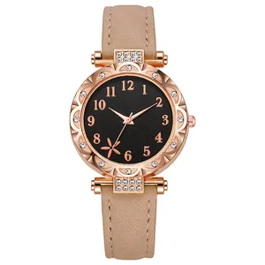 Detail van roségouden horloge met kristallen, zwarte bloemencijferplaat en beige lederen band