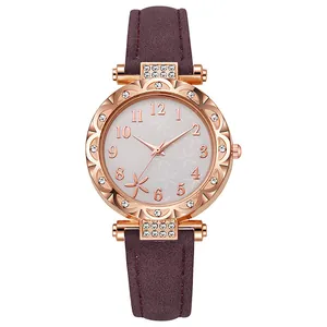 Detalle de reloj de cuarzo oro rosa con esfera floral y correa de cuero color burdeos