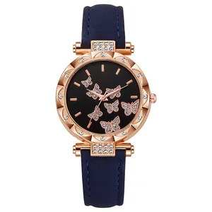 Close-up of rose gold watch face with butterfly patterns and rhinestone bezel detail