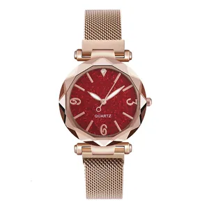 Dettaglio orologio al quarzo da donna con quadrante rosso stellato e cinturino a maglia rosa
