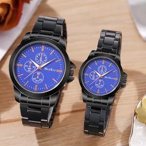 Détail de montres de couple avec bracelet en acier noir et cadran bleu sur fond bois