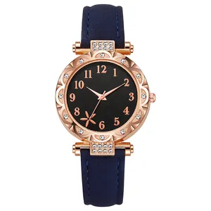 Detail van roségouden horlogekast met bloemvormige bezel en donkerblauwe lederen band