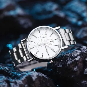 Close-up of a silver steel men's quartz watch with white dial on black textured rock