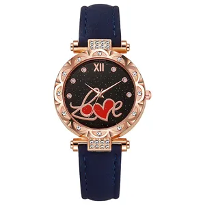 Détail de la montre strass or rose avec cadran étoilé et bracelet en cuir bleu foncé