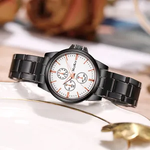 Détail de la montre McyKcy en acier noir avec cadran blanc posée sur une assiette en céramique