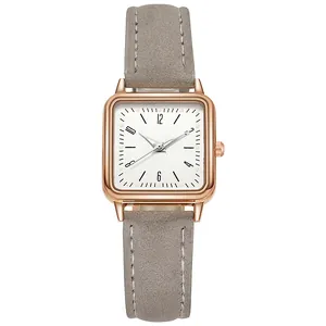 Detalle de reloj de cuarzo cuadrado para mujer con caja de oro rosa y correa de cuero gris