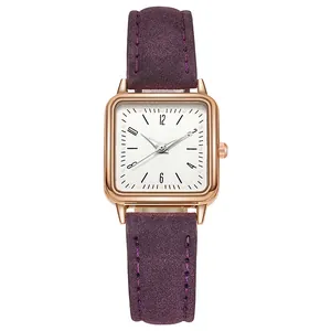 Detalle de un reloj cuadrado de oro rosa con esfera blanca y correa de ante color violeta