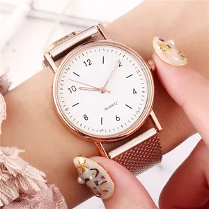 Nahaufnahme einer Damen-Quarzuhr in Roségold mit weißem Zifferblatt und Mesh-Armband am Handgelenk