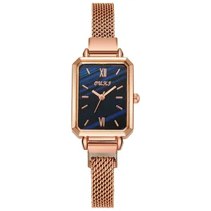 Detail of rose gold rectangular watch with blue wavy dial and mesh steel strap