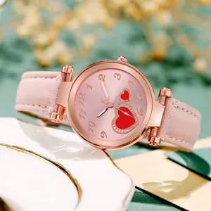 Macro shot of a rose gold heart watch on a ceramic plate with pink dial details