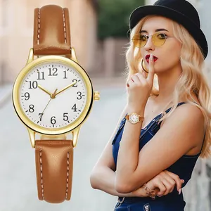 Dettaglio di un orologio da donna minimalista con cassa oro e cinturino marrone