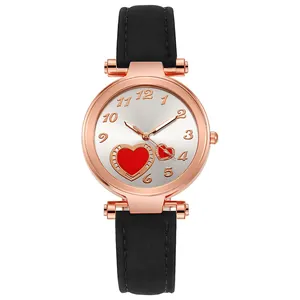 Close-up of rose gold watch face with red heart pattern and black leather strap
