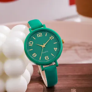 Detailed close-up of vibrant green quartz watch dial with gold Arabic numerals