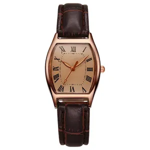Macro shot of rose gold tonneau watch case with Roman numeral dial and brown leather strap