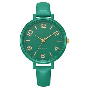 Detail of forest green leather strap and gold Arabic numeral dial on a quartz watch