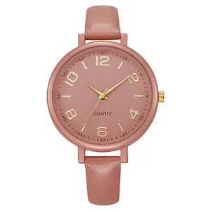 Detailed view of women's quartz watch featuring pink dial with gold numeral markers