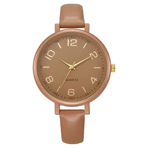 Macro detail of quartz watch with brown leather strap and rose gold numeral dial