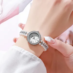 Detail of elegant pearl bracelet watch with shimmering mother of pearl dial for women
