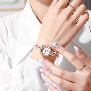 Macro detail of quartz watch with pearl chain strap and rhinestone bezel on wrist