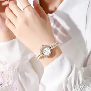 Close-up of elegant women quartz watch with pearl strap and crystal bezel on wrist