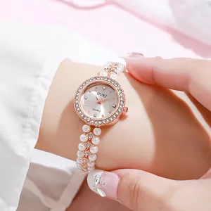 Close-up of rose gold watch case with crystal bezel and elegant pearl beaded strap