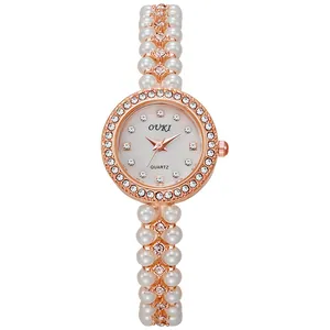 Macro view of women's watch featuring a mother-of-pearl dial and crystal-encrusted bezel