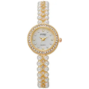 Detailed view of the luxury pearl bracelet strap and sparkling rhinestone bezel on the watch