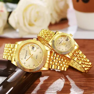 Classic gold couple watches with champagne dial and fluted bezel on a wooden table