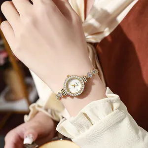 Close-up of a women gold quartz watch with rhinestones and elegant chain bracelet